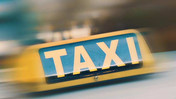 Das Bild zeigt ein Taxi Schild in Großaufnahme.